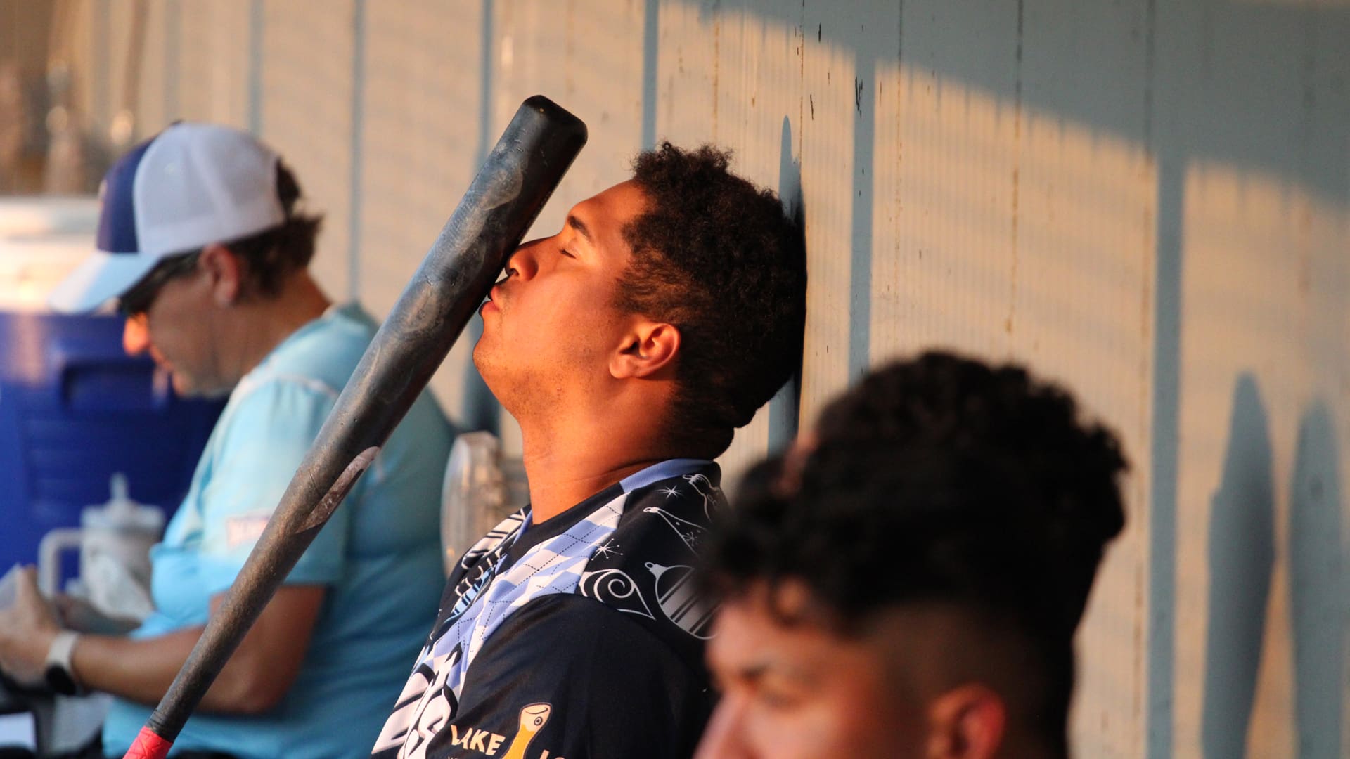 Ryan Hernandez searches for hits in his bat while sitting in the dugout.